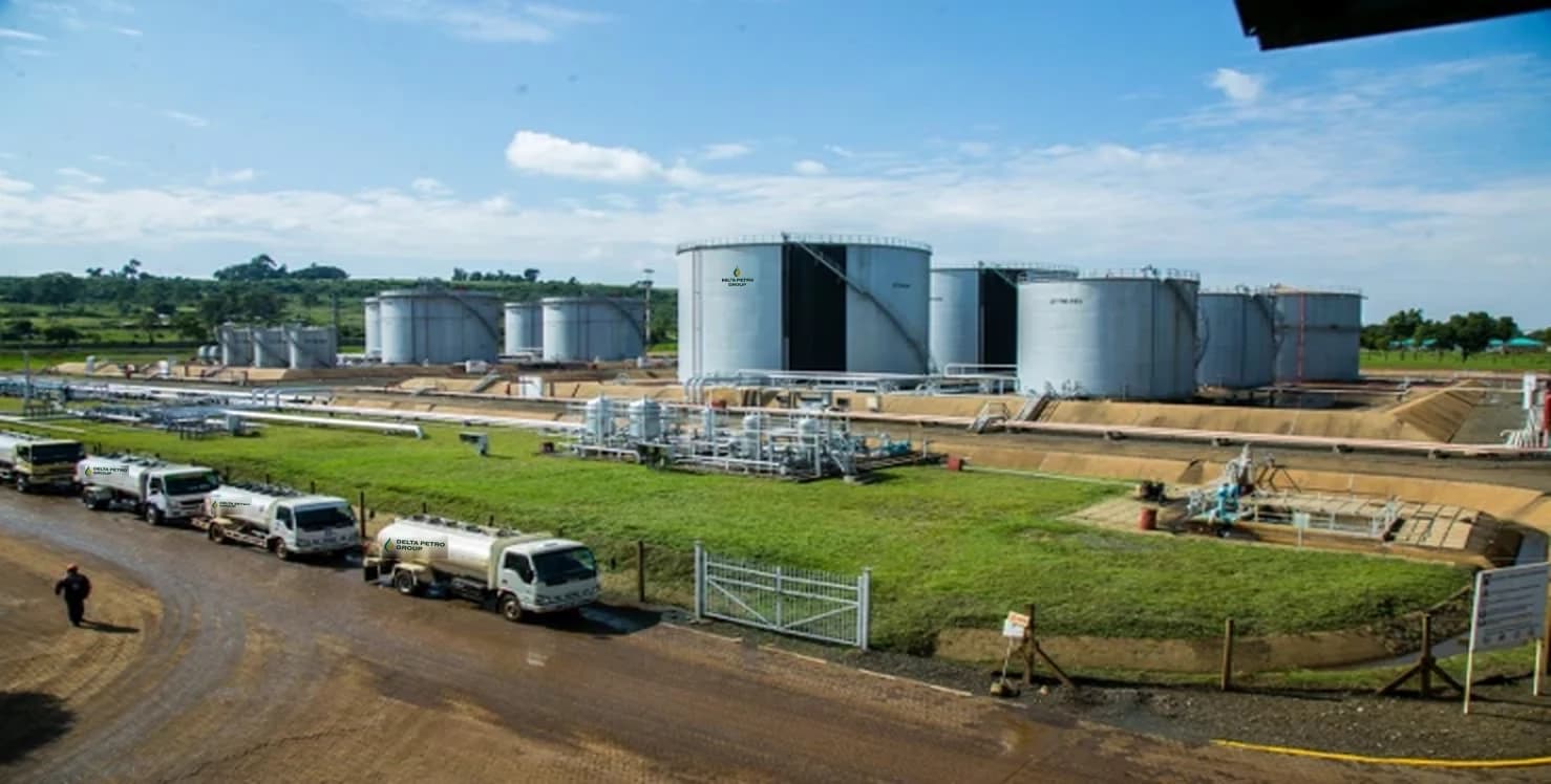 Delta Petro Group tanker trucks lined up beside a fuel depot with large storage tanks.